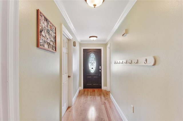 doorway with crown molding, baseboards, and light wood-type flooring