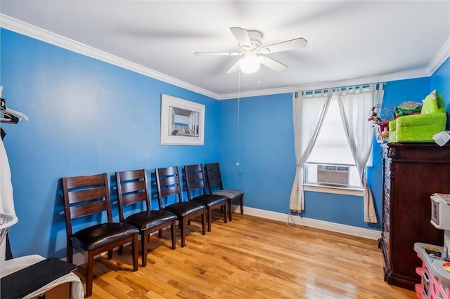 living area featuring baseboards, ornamental molding, light wood finished floors, and a ceiling fan