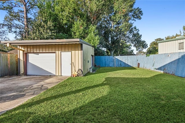 view of yard with a fenced backyard, a detached garage, an outdoor structure, and driveway