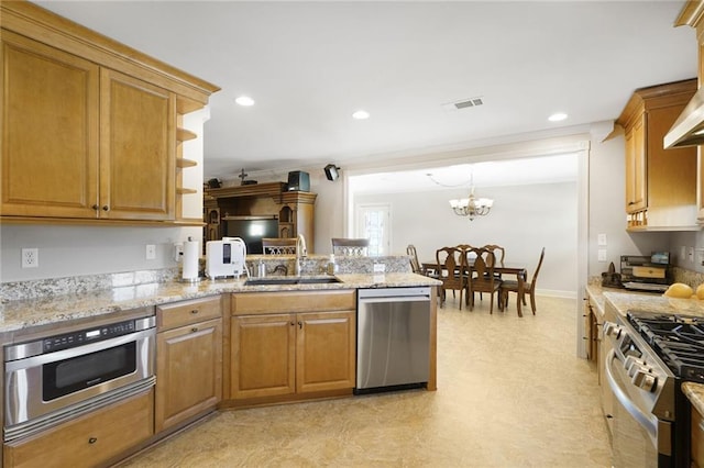 kitchen with a sink, light stone countertops, appliances with stainless steel finishes, a peninsula, and recessed lighting