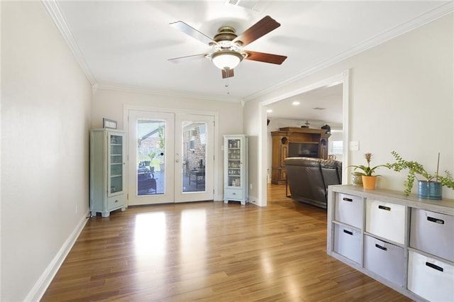 living area featuring french doors, ornamental molding, light wood-style floors, and ceiling fan