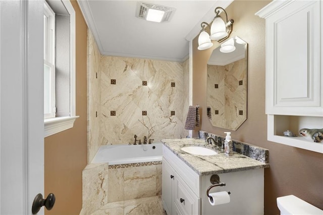 bathroom with vanity, tiled bath, toilet, ornamental molding, and visible vents