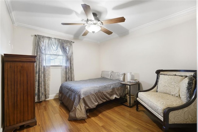 bedroom with wood finished floors, ceiling fan, and ornamental molding