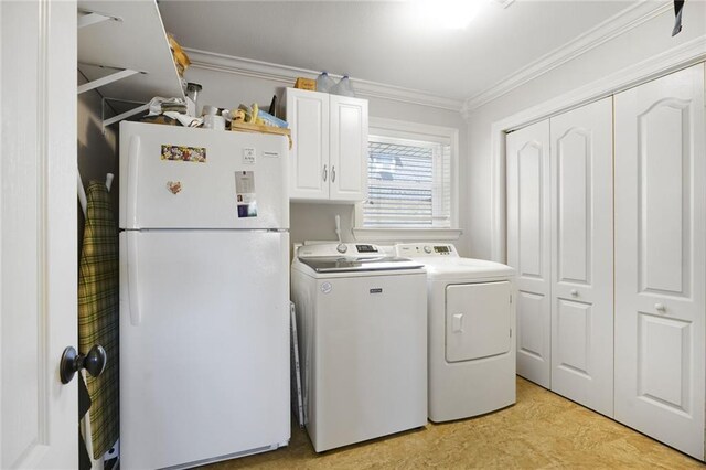 clothes washing area featuring washing machine and clothes dryer, cabinet space, crown molding, and light floors