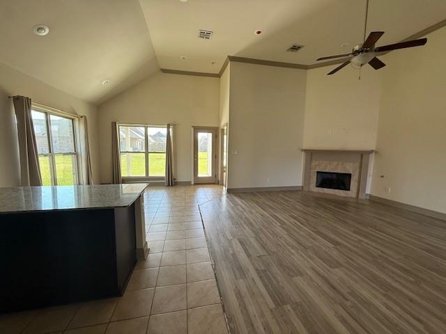 17657 Golden Eagle Dr, Prairieville, LA 70769 - unfurnished living room with a fireplace, ceiling fan, visible vents, and plenty of natural light