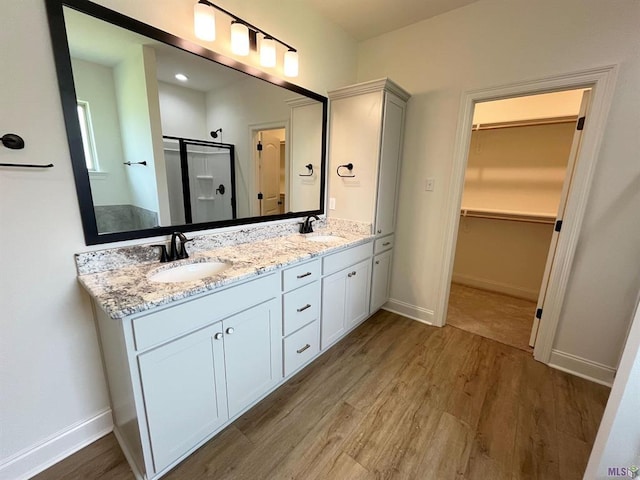 129 Olivia Dr, Luling, LA 70070 - full bathroom with wood finished floors, a shower stall, double vanity, and a spacious closet