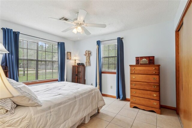 65398 Maple St, Mandeville, LA 70448 - bedroom featuring light tile patterned flooring, baseboards, a textured ceiling, and a ceiling fan
