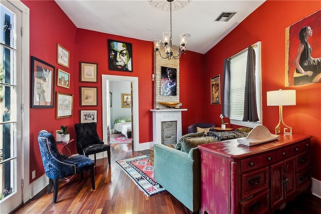 3342 Bell St, New Orleans, LA 70119 - living room with a large fireplace, visible vents, a chandelier, baseboards, and wood finished floors