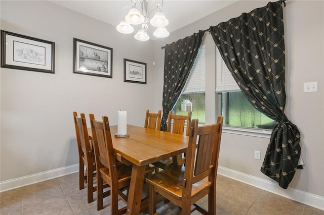 dining room with a chandelier, baseboards, and tile patterned floors