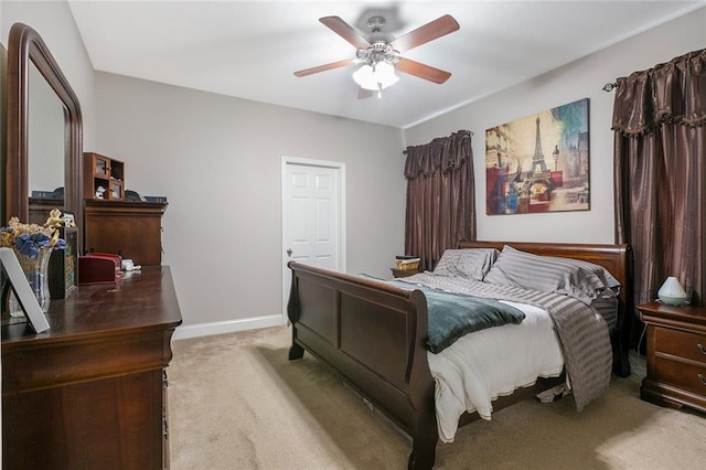 bedroom featuring light colored carpet, baseboards, and ceiling fan