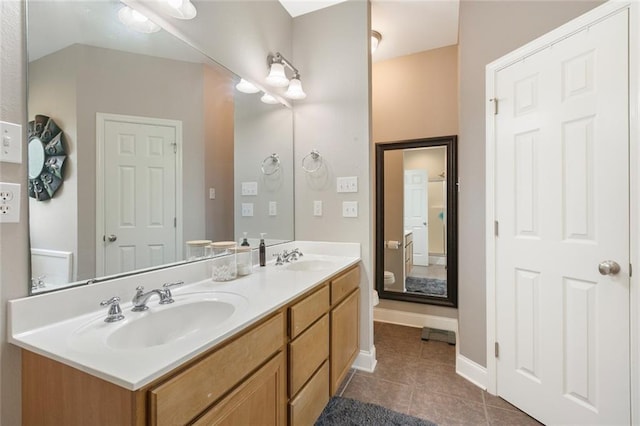 full bathroom with a sink, double vanity, baseboards, and tile patterned floors
