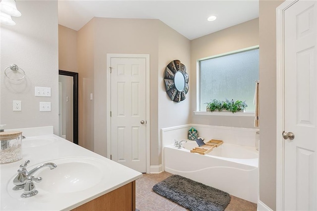 full bathroom with a sink, baseboards, tile patterned floors, double vanity, and a garden tub