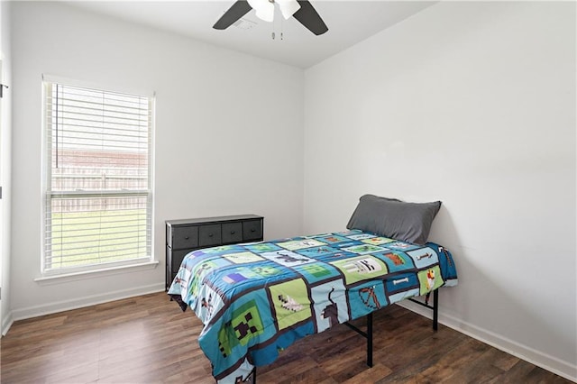 bedroom featuring baseboards, wood finished floors, and ceiling fan
