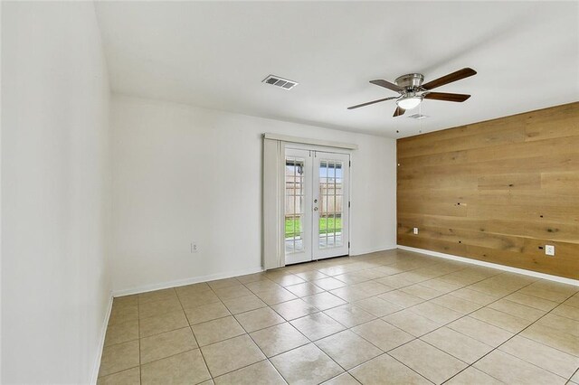 3013 Volpe Dr, Chalmette, LA 70043 - spare room featuring wooden walls, light tile patterned flooring, ceiling fan, french doors, and visible vents