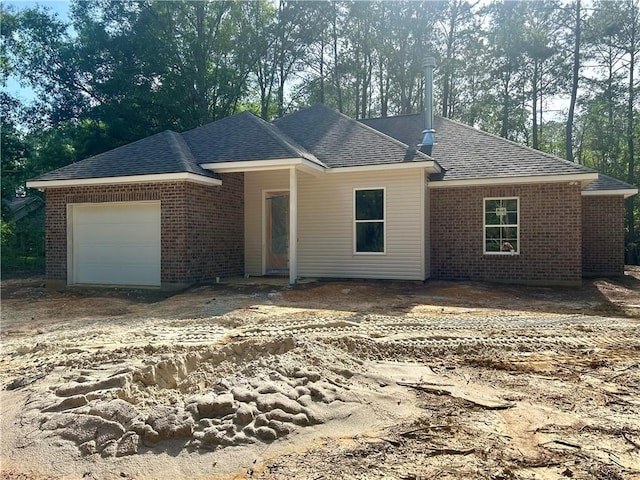75396 Henderson Rd, Covington, LA 70435 - single story home featuring brick siding, an attached garage, a shingled roof, and view of wooded area