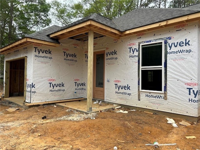 entrance to property with a shingled roof