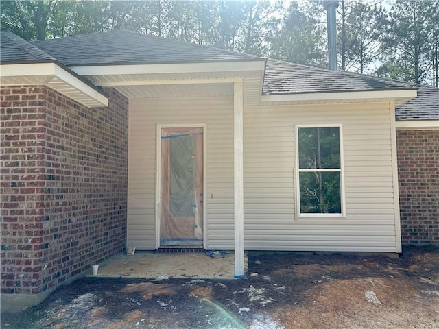 75396 Henderson Rd, Covington, LA 70435 - property entrance featuring a shingled roof and brick siding