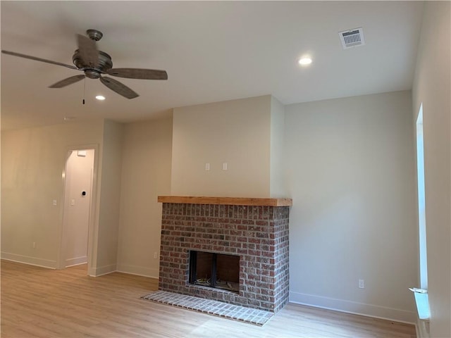 75396 Henderson Rd, Covington, LA 70435 - unfurnished living room featuring light wood-style floors, a brick fireplace, ceiling fan, and recessed lighting