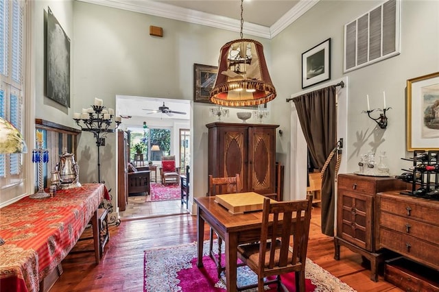 1838 Burgundy St, New Orleans, LA 70116 - dining space featuring ornamental molding, a high ceiling, visible vents, a ceiling fan, and wood finished floors