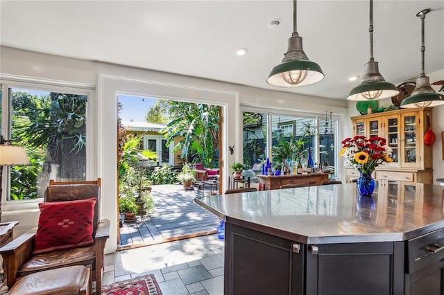 1838 Burgundy St, New Orleans, LA 70116 - kitchen with stainless steel counters, recessed lighting, dark cabinetry, hanging light fixtures, and stone tile floors