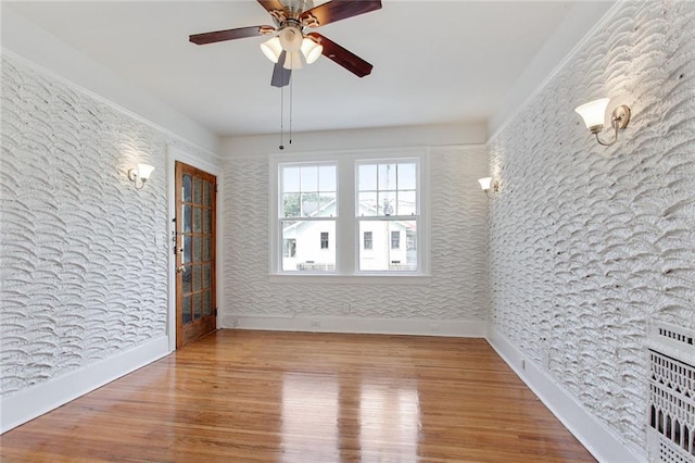 4237 Fontainebleau Dr, New Orleans, LA 70125 - spare room featuring wood finished floors, ceiling fan, and wallpapered walls
