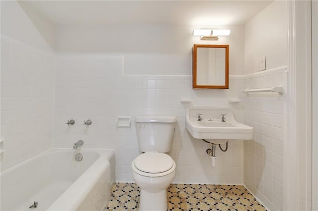 4237 Fontainebleau Dr, New Orleans, LA 70125 - bathroom featuring a bathtub, tile walls, and a wainscoted wall