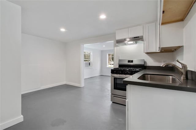 4237 Fontainebleau Dr, New Orleans, LA 70125 - kitchen with stainless steel range with gas cooktop, under cabinet range hood, dark countertops, white cabinets, and concrete floors