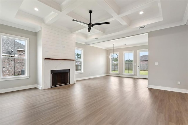 unfurnished living room with wood finished floors, coffered ceiling, baseboards, and visible vents