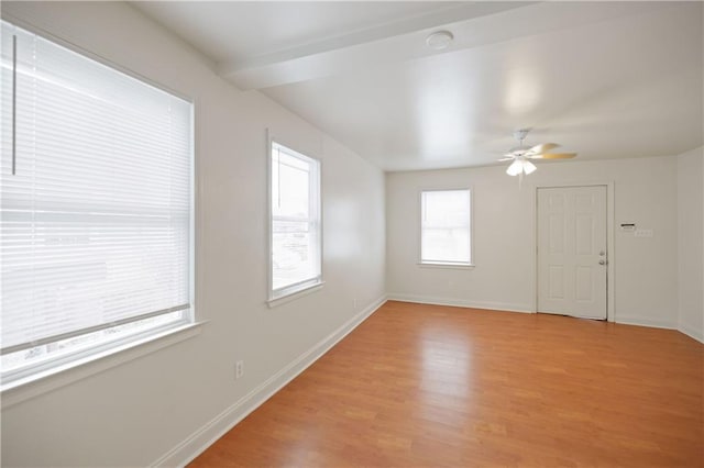 spare room with baseboards, a ceiling fan, and light wood finished floors