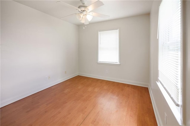 spare room with baseboards, a ceiling fan, and light wood-style flooring