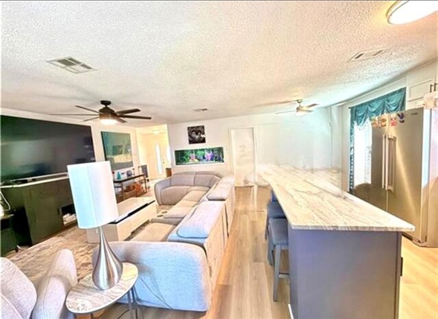 2516 E Pearl Dr, Marrero, LA 70072 - living area with ceiling fan, a textured ceiling, and light wood-type flooring