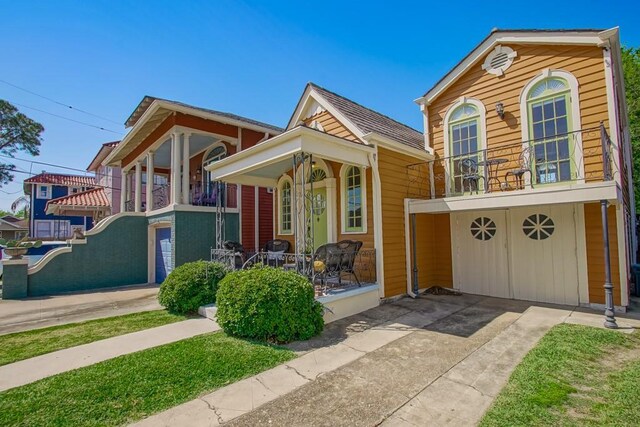 3611 Elaine Pl, New Orleans, LA 70119 - view of front facade featuring a porch, an attached garage, driveway, and a balcony