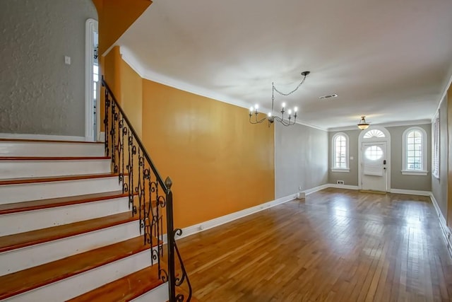 3611 Elaine Pl, New Orleans, LA 70119 - entryway with visible vents, an inviting chandelier, ornamental molding, and wood finished floors
