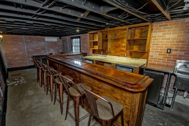 3611 Elaine Pl, New Orleans, LA 70119 - bar with indoor wet bar, brick wall, concrete flooring, and a wall mounted air conditioner