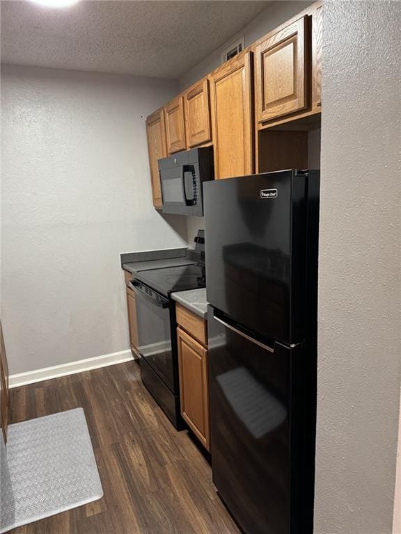 4518 Y A Tittle Ave Unit 6, Baton Rouge, LA 70820 - kitchen featuring a textured ceiling, dark wood finished floors, brown cabinetry, baseboards, and black appliances