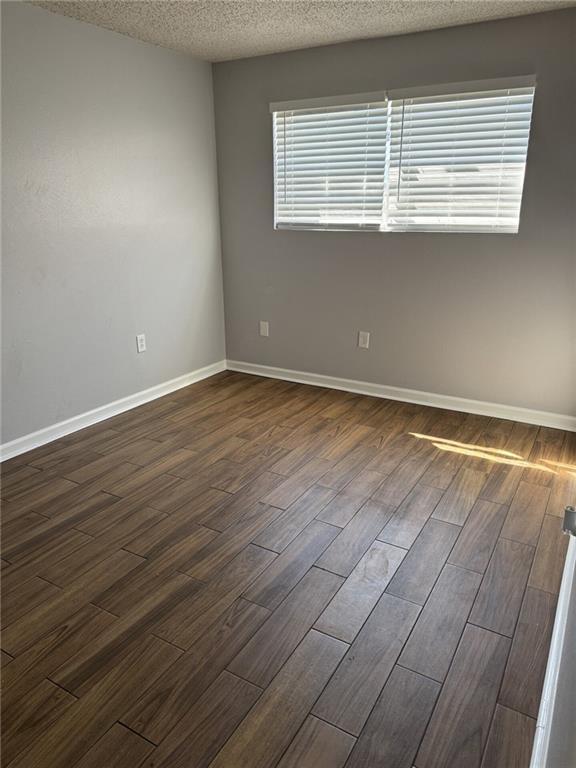 4518 Y A Tittle Ave Unit 6, Baton Rouge, LA 70820 - spare room with dark wood-type flooring, baseboards, and a textured ceiling