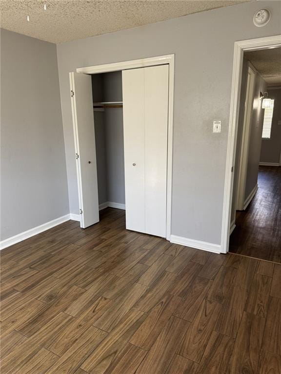 4518 Y A Tittle Ave Unit 6, Baton Rouge, LA 70820 - unfurnished bedroom with dark wood-type flooring, a textured ceiling, baseboards, and a closet