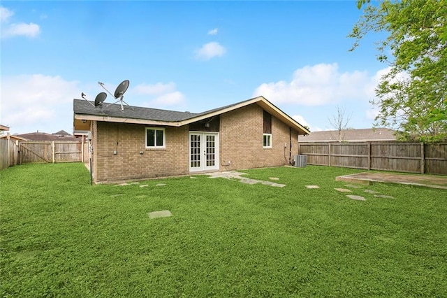 4741 Lafon Dr, New Orleans, LA 70126 - back of house with french doors, brick siding, central air condition unit, and a yard