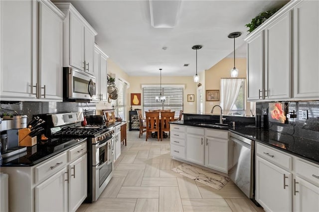 301 Clover Meadows Dr, Covington, LA 70433 - kitchen with appliances with stainless steel finishes, a sink, tasteful backsplash, a peninsula, and white cabinets