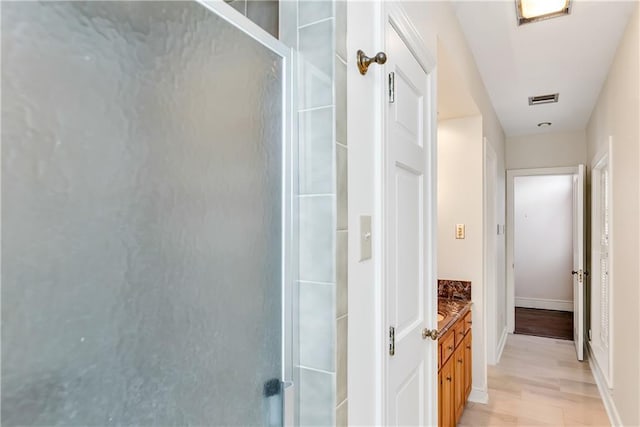 corridor featuring light wood-style flooring and visible vents
