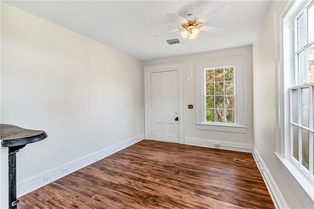 foyer featuring a ceiling fan, baseboards, and dark wood-type flooring