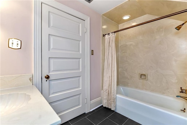 bathroom with tile patterned floors, shower / bath combo with shower curtain, and a sink