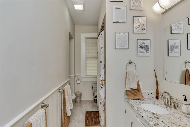 bathroom with wainscoting, vanity, and visible vents