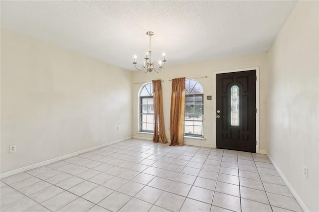 9180 Dancy Ave, Baton Rouge, LA 70814 - foyer with light tile patterned flooring, baseboards, a notable chandelier, and a textured ceiling