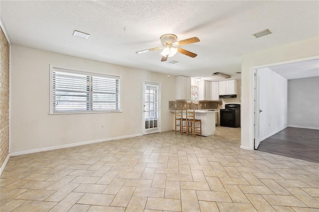 9180 Dancy Ave, Baton Rouge, LA 70814 - unfurnished living room featuring baseboards, a textured ceiling, and ceiling fan
