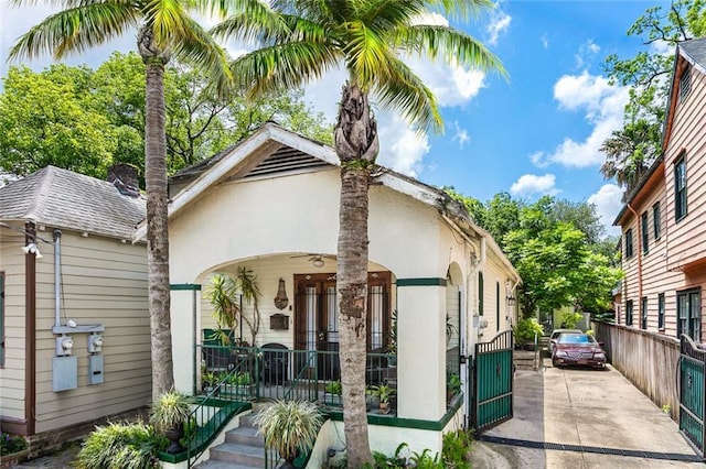 1830 Burgundy St, New Orleans, LA 70116 - view of front of property with covered porch, stucco siding, a gate, and driveway