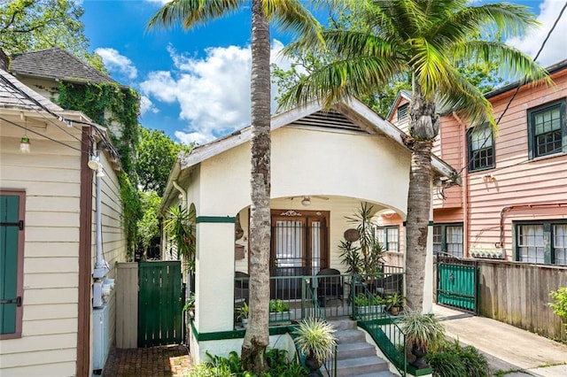 1830 Burgundy St, New Orleans, LA 70116 - view of front of home with a gate, stucco siding, a fenced front yard, and covered porch