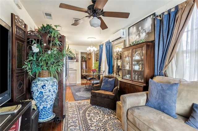 1830 Burgundy St, New Orleans, LA 70116 - living area featuring a wall unit AC, wood finished floors, ceiling fan, a chandelier, and healthy amount of natural light