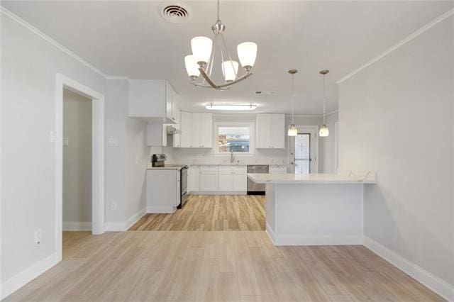 kitchen with light countertops, ornamental molding, stainless steel appliances, white cabinetry, and light wood-style floors
