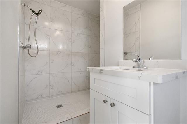 full bathroom featuring vanity and a tile shower